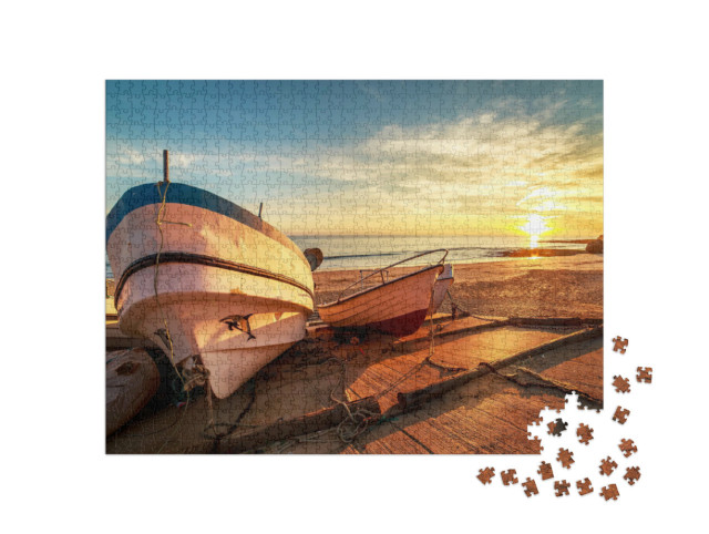 Puzzle 1000 Teile „Hölzerne Fischerboote in einem kleinen Hafen am Strand bei Sonnenuntergang“