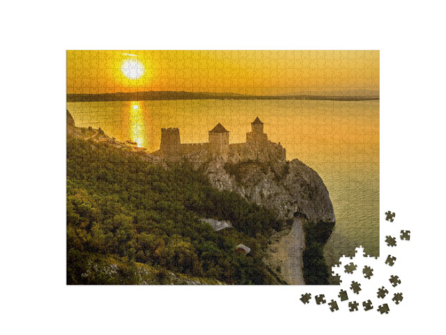 Puzzle 1000 Teile „Silhouette der Burg Golubac bei Sonnenuntergang in Serbien entlang der Donau“