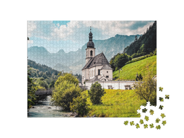 Puzzle 1000 Teile „Landschaft in den Alpen mit der Kirche St. Sebastian an einem Gebirgsfluss“