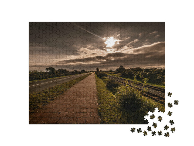 Puzzle 1000 Teile „Malerischer Blick auf Schienen und Straße in Borkum“