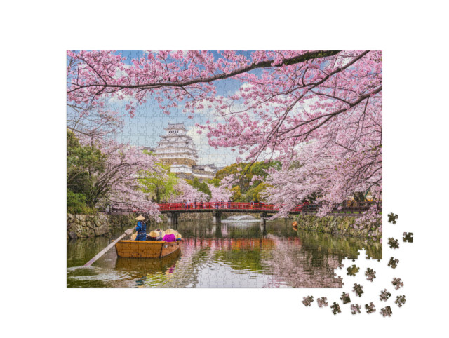 Puzzle 1000 Teile „Majestätische Burg über der Stadt Himeji während der Kirschblüte in Japan“